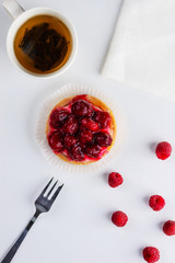 Tartlet with raspberries and a cup of green tea
