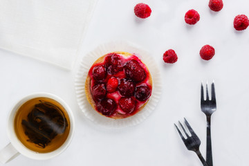 Tartlet with raspberries and a cup of green tea