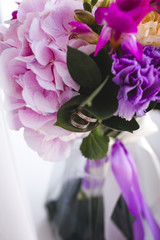 Purple bouquet with wedding rings