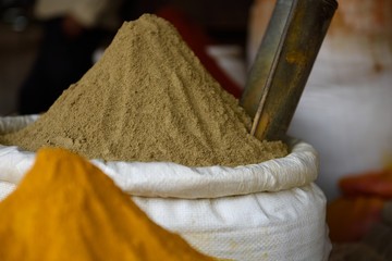 Basket of fresh ground raw Indian coriander powder, or dhania, in a spice market in Jaipur, Rajasthan, India