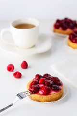 Tartlets with raspberries and a cup of green tea