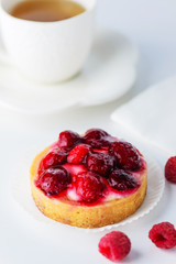 Tartlet with raspberries and a cup of green tea