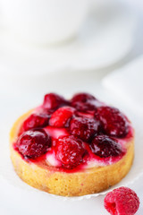 Tartlet with raspberries and a cup of green tea