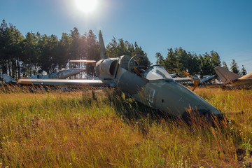 Abandoned broken old military fighter airplanes on grassy ground