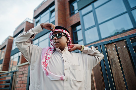 Middle Eastern arab business man posed on street against modern building with sunglasses.