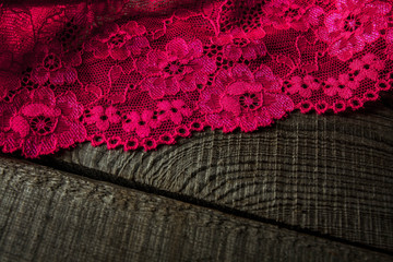 Fototapeta na wymiar Pink crochet lace on a wooden surface