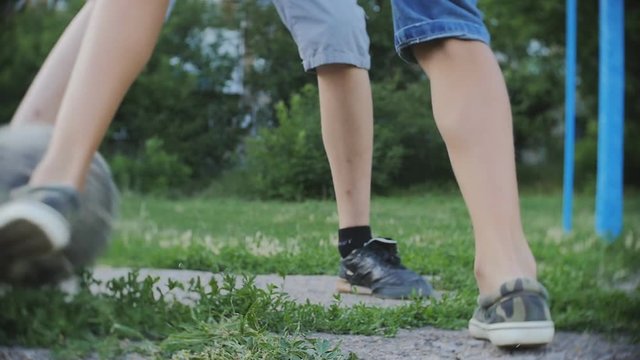 Teenagers playing football soccer outdoors, boys enjoying active hobby in park, slow motion