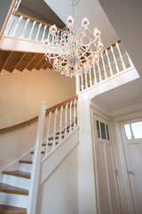 Beautiful staircase in victorian style with crystal chandelier and decorative railing