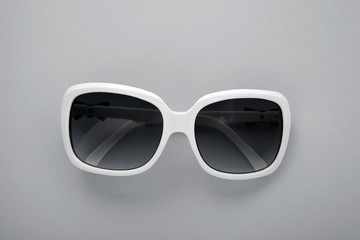 Summer background. Sunglasses isolated on grey background. Top view and copy space.