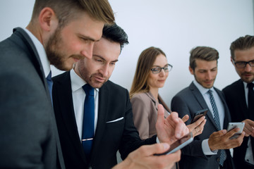 business team looking at the screens of their smartphones