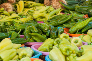 closeup of green peppers piles at the market