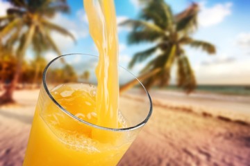 Orange juice glass on beach