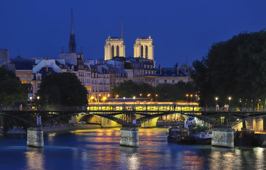 Fototapeta na wymiar The night view of Seine river during the night with some touristic bridges like Pont des Arts and Pont Neuf, Paris, France.