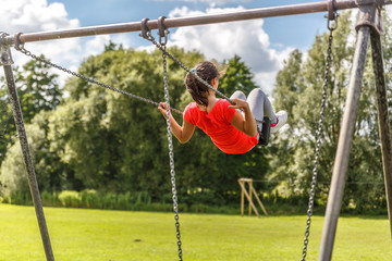 A girl swings peacefully on a large swing