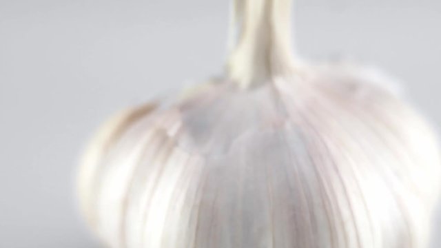 Macro shot of garlic is on a white table with white background. Prepearing for cooking.