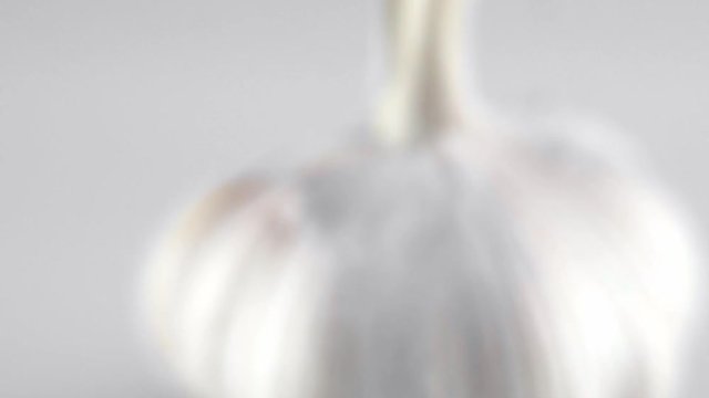 Macro shot of garlic is on a white table with white background. Prepearing for cooking.