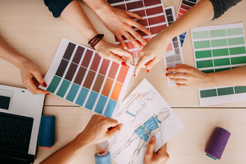 Fashion designers and colorists creating new collection in studio. Professional team choosing the...