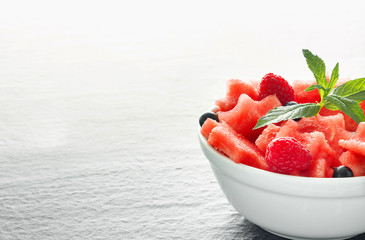 Salad of fresh juicy pieces of watermelon, raspberry and currant with green mint leaves