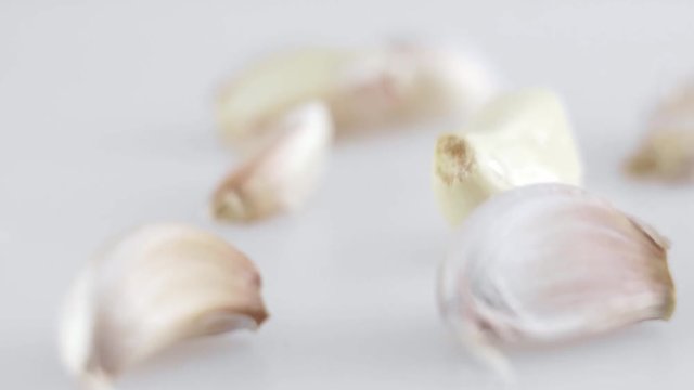 Macro shot of many pieces of garlic is on a white table with white background. Preparing for cooking.