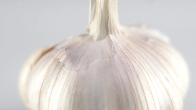 Macro shot of garlic is on a white table with white background. Prepearing for cooking.