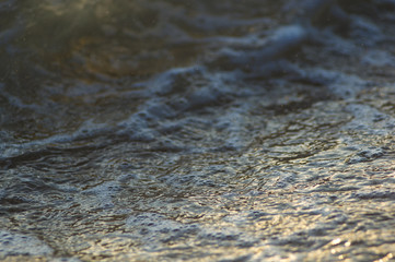 pebble stones on the sea beach, the rolling waves of the sea with foam