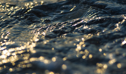 pebble stones on the sea beach, the rolling waves of the sea with foam