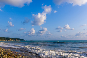sea landscape is a pebbly beach with waves in white foam