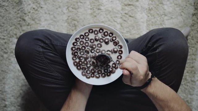 Man holding bowl with chocolate cereal, top view. Healthy eating, dieting concept
