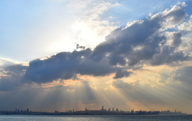 sight of Beirut, Lebanon, shot from a distance after the rain  with a big atmospheric cloud  and rays of light  above the city