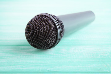 Black microphone on mint wooden table
