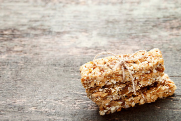 Tasty granola bars on grey wooden table