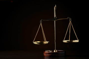 Scales of justice on wooden table