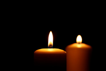 Burning candles on black background