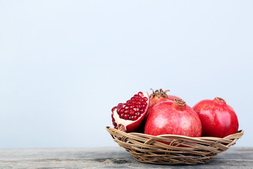 Ripe and juicy pomegranate in basket on grey wooden table © 5second