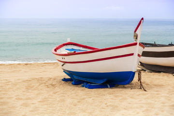 Wooden fishing boat on a sandy beach in sunny day. Place for text