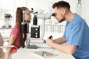 Ophthalmologist examining little girl in clinic