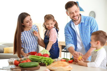 Happy family with children having breakfast in kitchen