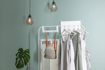 Stylish dressing room interior with clothes on rack