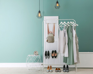 Stylish dressing room interior with clothes on rack