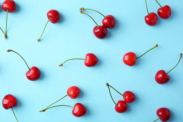Obraz na płótnie Canvas Ripe red cherries on color background, top view