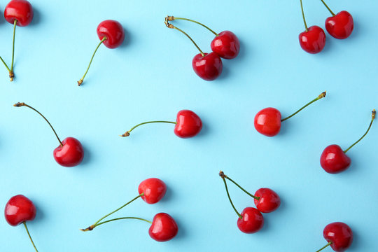 Ripe red cherries on color background, top view