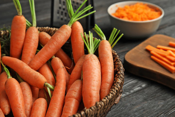 Bowl with ripe carrots on table, closeup