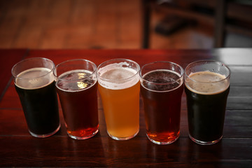 Glasses of different beer on table indoors