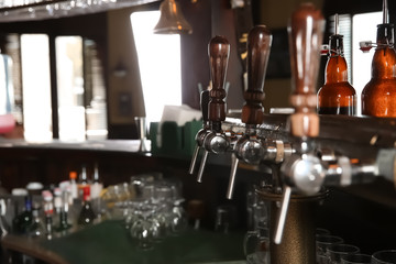 Fototapeta na wymiar Beer taps at counter in modern bar