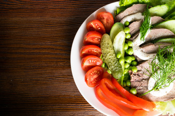 boiled tongue with vegetables tomatoes red pepper cucumber lettuce peas with mayonnaise with wooden board