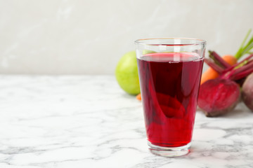 Glass with fresh beet juice on table