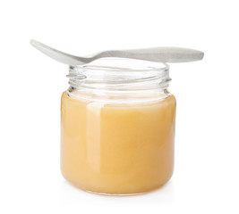 Jar with delicious honey and spoon on white background