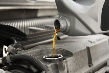 Pouring oil into car engine, closeup