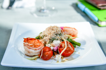Fried shrimp with tomatoes, asparagus, green beans, decorated with flowers.