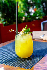 Yellow lemonade with mint in a glass on the restaurant table.